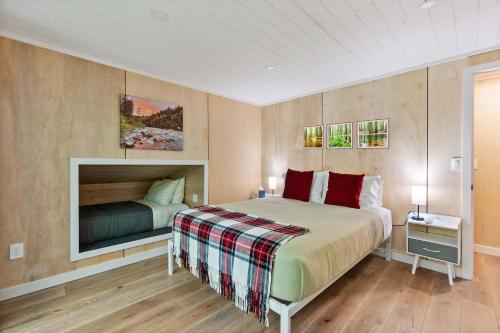 Un dormitorio con una cama y un televisor en la pared. en Sauk River Cabins - Hot tub - Firepit, en Darrington