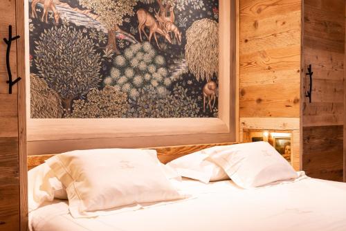 a bed with two pillows in a room with a painting at Auberge de La Maison in Courmayeur