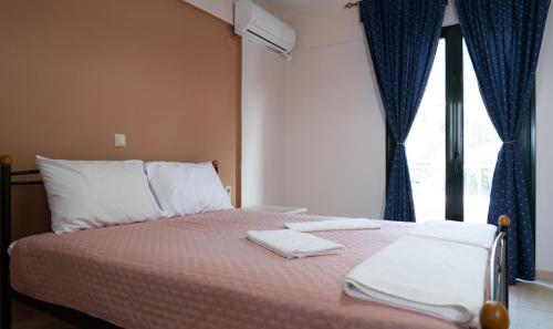 a bed with two towels on it with a window at Sina Family in Piskopianon