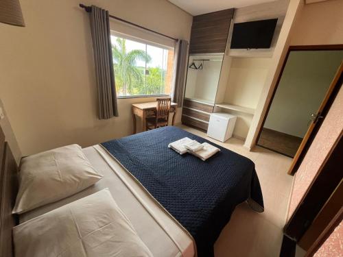 a bedroom with a bed with two towels on it at La Palma Hotel Fazenda in Indaiatuba