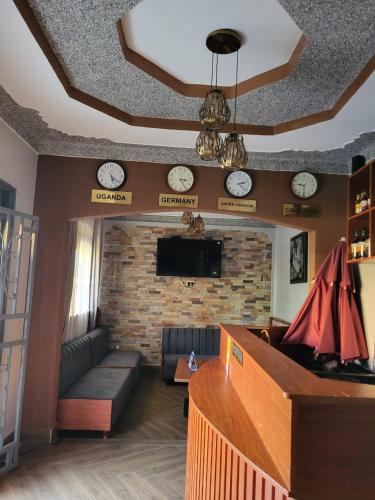 sala de estar con sofá y reloj en la pared en Greena Royal Suites, en Mityana