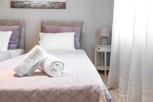 a bedroom with two beds with towels on the bed at Chara’s Luxury home in Kalabaka