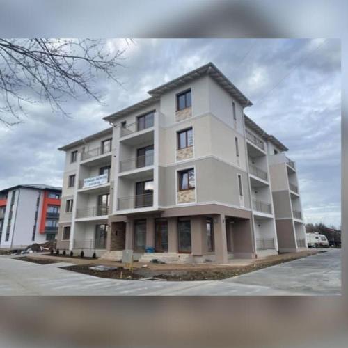 a large white apartment building in a parking lot at A&A Luxury Apartment in Giroc