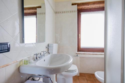 biała łazienka z umywalką i toaletą w obiekcie Agriturismo Antica Dimora Del Turco w mieście Sona