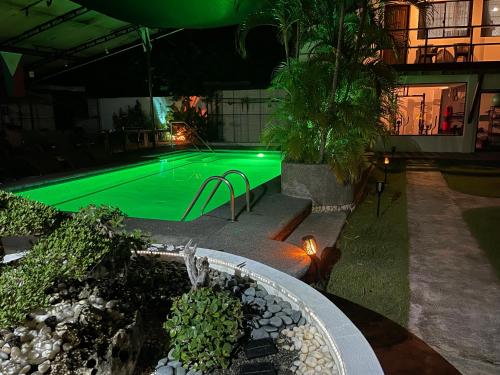 a swimming pool at night with green illumination at Parrot Resort Moalboal in Moalboal