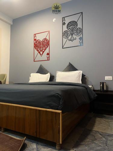 a bed in a room with paintings on the wall at HOM House of MannMauji Riverside kasol in Kasol