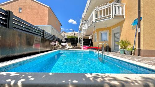 a swimming pool in the backyard of a house at Apartman Stipić 2 in Kaštela