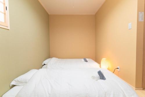 a bedroom with a white bed with two pillows at NEW OPEN Comfortable newly built house stay 2-minute walk from Bentencho Station in Osaka