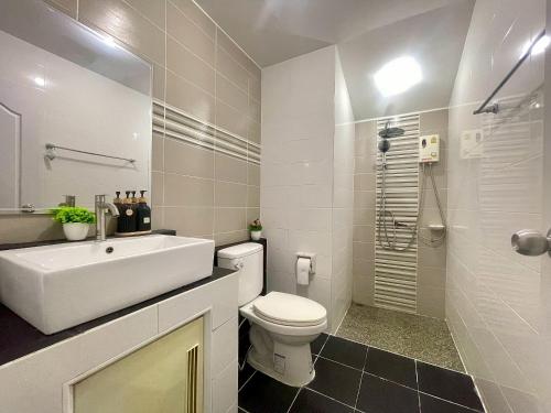 a white bathroom with a sink and a toilet at Private Pool Getaway - Baan Hug Ubon Warinchamrap in Ubon Ratchathani