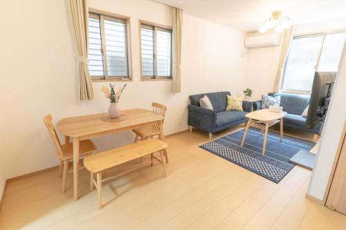 a living room with a table and a couch at NEW OPEN Comfortable newly built house stay 2-minute walk from Bentencho Station in Osaka