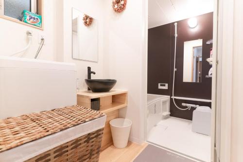 a bathroom with a sink and a toilet and a mirror at NEW OPEN Comfortable newly built house stay 2-minute walk from Bentencho Station in Osaka