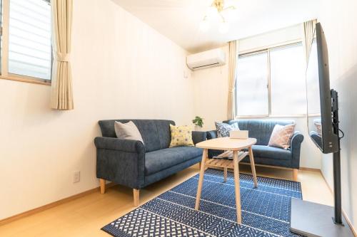 a living room with a couch and a table at NEW OPEN Comfortable newly built house stay 2-minute walk from Bentencho Station in Osaka