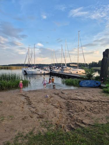 a group of children playing in the water at a marina at Pensjonat Rybaczówka - noclegi, restauracja, port in Giżycko