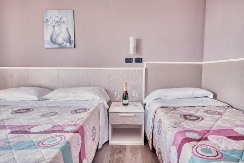 two beds sitting next to each other in a bedroom at Hotel Astoria in Bordighera
