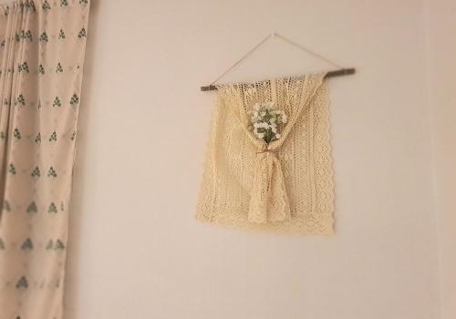 a curtain with a bouquet of flowers hanging on a wall at Soo Stay in Daegu
