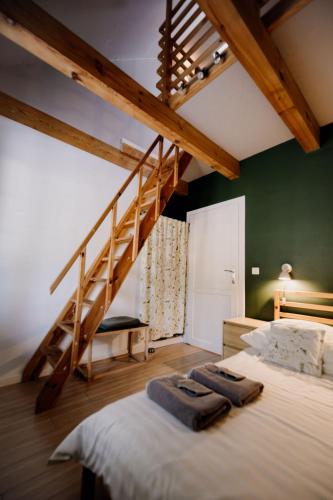 a bedroom with a large bed with a staircase at Bukolik in Bukowiec