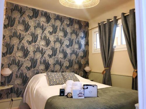 - une chambre avec un lit et du papier peint fleuri dans l'établissement 30m2 - Clim - wifi - 100m des plages, à Fréjus