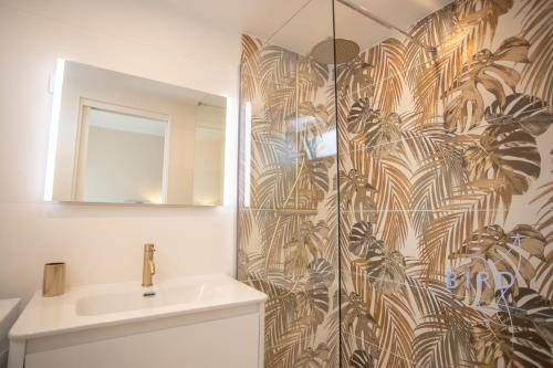 une salle de bain avec une douche avec un lavabo et un miroir dans l'établissement Cozy renovated apartment with sea view, à Cannes