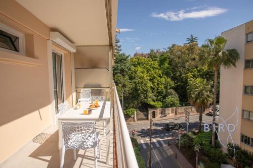 d'un balcon avec une table et des chaises offrant une vue sur la rue. dans l'établissement Cozy renovated apartment with sea view, à Cannes