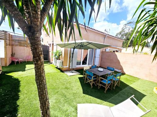 une terrasse avec une table et des chaises sous un parasol dans l'établissement Les 4 Mas, à Bormes-les-Mimosas