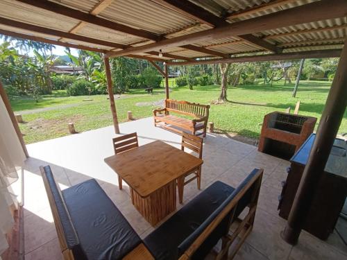 a patio with a table and chairs and a bench at Pousada e Restaurante Dona Siroba in Morretes