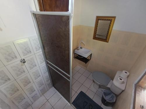 a bathroom with a shower and a toilet and a sink at Pousada e Restaurante Dona Siroba in Morretes