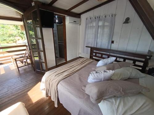 a bedroom with a large bed with two pillows at Pousada e Restaurante Dona Siroba in Morretes