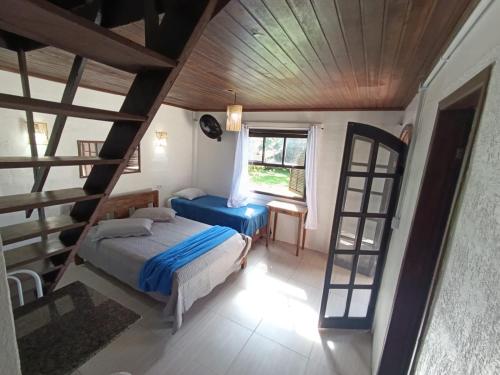 a bedroom with a bed and a ladder at Pousada e Restaurante Dona Siroba in Morretes