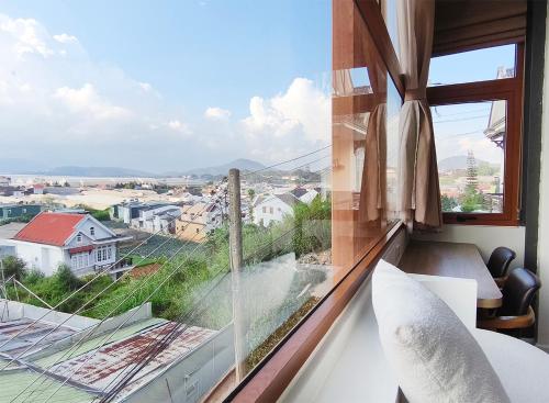 a room with a large window with a view of a city at Meraki Villa Đà Lạt in Khu Chi Lăng