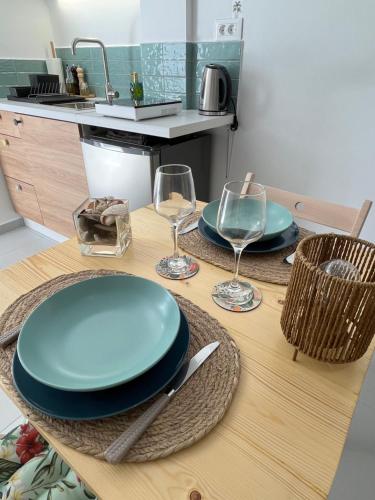 a table with plates and wine glasses on it at Blue Bergamote Syros in Ermoupoli
