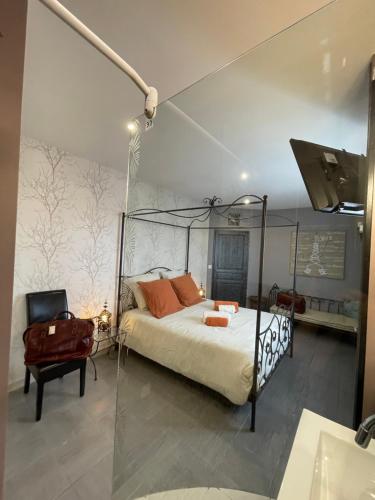 une chambre avec un lit à baldaquin et une chaise dans l'établissement Bienvenue Vacances Sarlat-La-Canéda, à Proissans