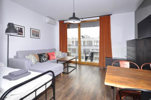 a living room with a couch and a table at Schindler’s Factory Zabłocie Deluxe Apartments WAWELOFTS in Kraków