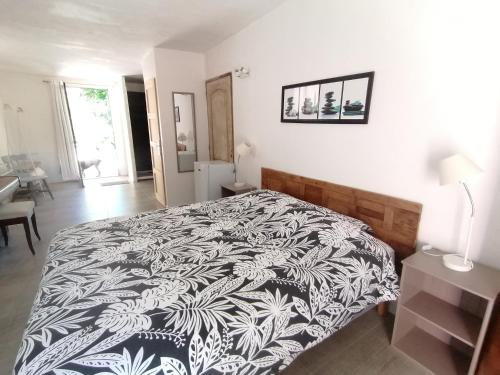 ein Schlafzimmer mit einem Bett mit einer schwarzen und weißen Decke in der Unterkunft Hacienda, villaT4 de 110m2 proche de St Florent in Patrimonio