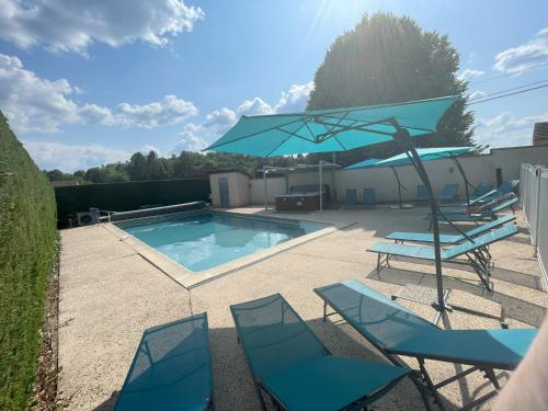 une terrasse avec des chaises et un parasol ainsi qu'une piscine dans l'établissement Bienvenue Vacances Sarlat-La-Canéda, à Proissans