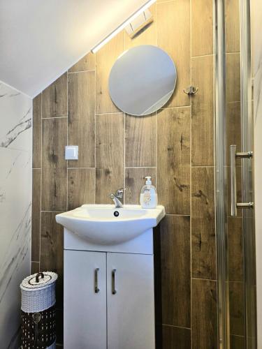 a bathroom with a sink and a mirror at Agroturystyka Gawryś pokoje in Sasino