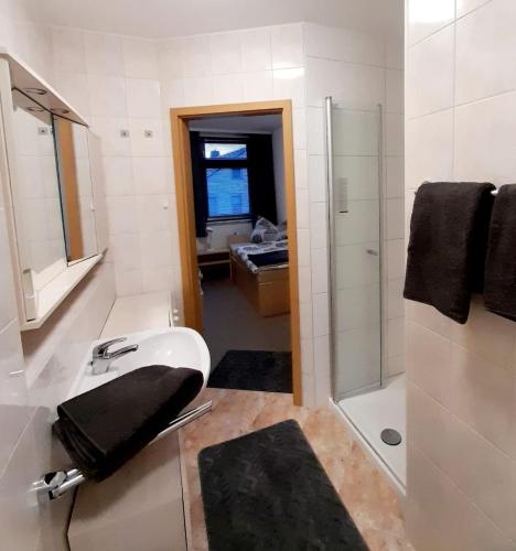 a white bathroom with a sink and a shower at Großzügige, komfortable Wohnung in Burgstaedt