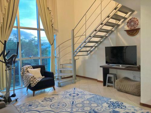 a living room with a staircase and a television at Saint Sebastian Flat 310 Com Hidro até 2 pessoas in Jaraguá do Sul