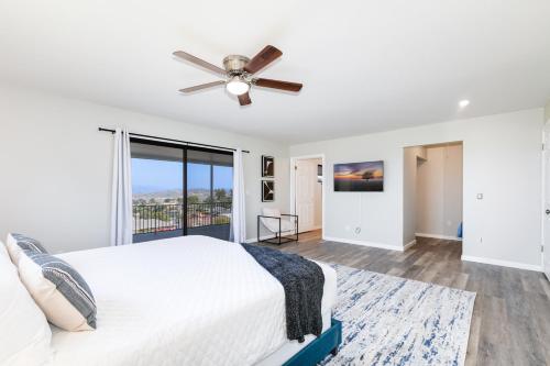a bedroom with a white bed and a ceiling fan at Sleeps 31 10br Mountain View, Pool, Spa and Games in El Cajon
