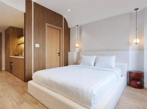 a bedroom with a large white bed with white sheets at Meraki Villa Đà Lạt in Khu Chi Lăng