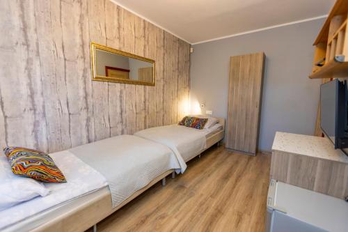 a bedroom with two beds and a mirror on the wall at Gościniec Pod Markizami in Malbork