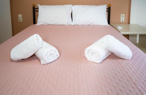 a bed with two rolls of towels on it at Sina Family in Piskopianon