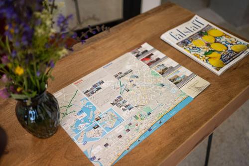 a wooden table with a vase of flowers and a map at cs veniceflat Apartment - Venice - Apt Vce - 15' from Venice in Tessera
