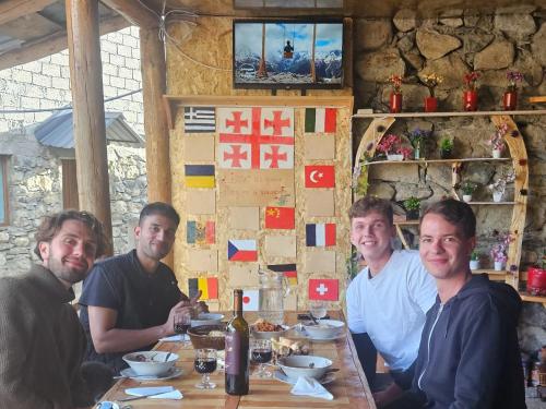 a group of men sitting at a table in a restaurant at MURQVAMI Guesthouse in Adishi