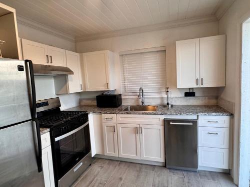 a kitchen with white cabinets and a sink at Best Location In Exuma - George Town in Georgetown