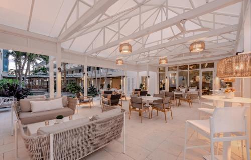 a conservatory with tables and chairs and a patio at Lido Beach Resort - Sarasota in Sarasota