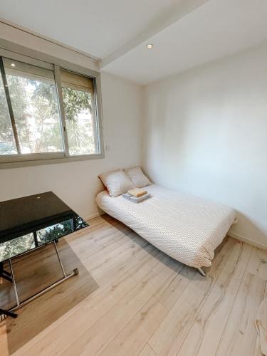 une chambre avec un lit et une table dedans dans l'établissement Charmant studio près de l'aéroport & parking, à Nice