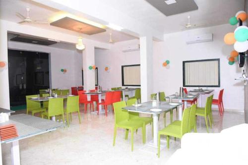 una sala da pranzo con tavoli, sedie e palloncini di Hotel O SANVI RESORT a Pune