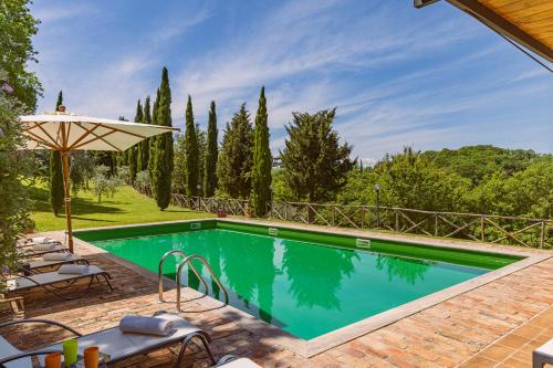 an outdoor swimming pool with chairs and an umbrella at PODERE BAIOCCO TENUTA in Città della Pieve