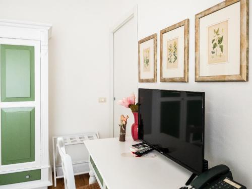 a television sitting on a white table in a room at Hotel Donatella in Posada