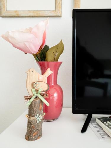 a red vase sitting on a desk next to a computer monitor at Hotel Donatella in Posada